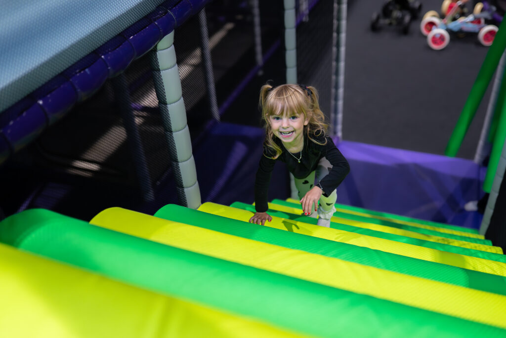 Flicka utforskar Jumpys lekträdgård